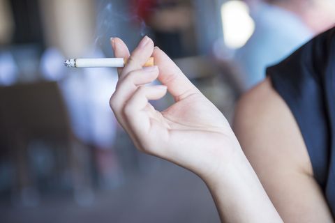 Eine Frau hält eine Zigarette in der Hand