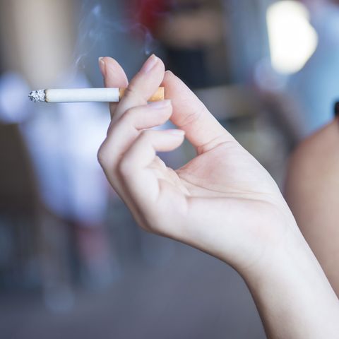 Eine Frau hält eine Zigarette in der Hand