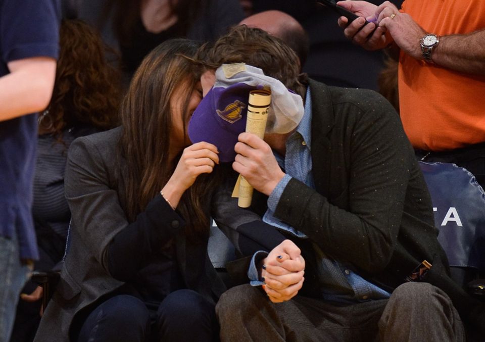 Ashton Kutcher und Mila Kunis verstecken ihre Gesichter hinter einer Baseball-Kappe
