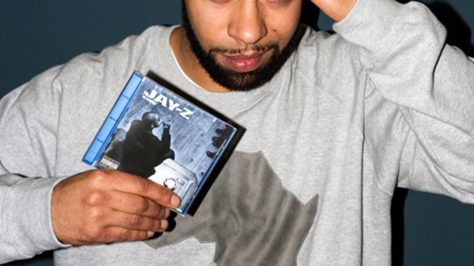 Megaloh hält das Album »The Blueprint« von Jay-Z in der Hand