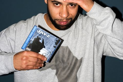 Megaloh hält das Album »The Blueprint« von Jay-Z in der Hand