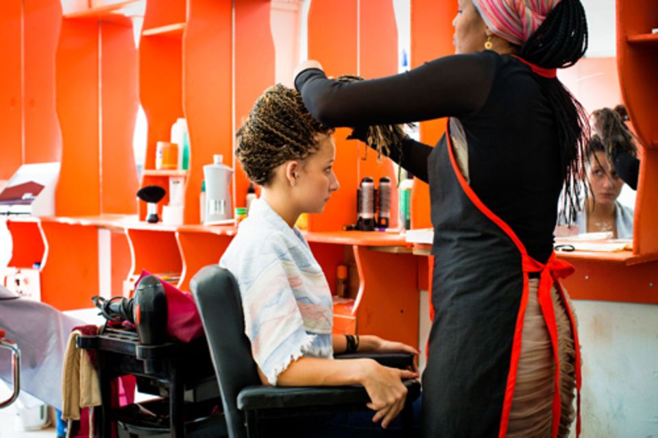 Freizeit: Deena lässt sich in einem Schönheitssalon ihre geflochtenen Zöpfe zu einer Hochsteckfrisur zusammennähen. Manchmal wünscht sie sich, sie wäre als Schwarze geboren. Freizeit: Deena lässt sich in einem Schönheitssalon ihre geflochtenen Zöpfe zu einer Hochsteckfrisur zusammennähen. Manchmal wünscht sie sich, sie wäre als Schwarze geboren.