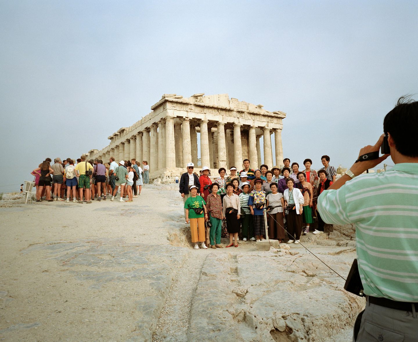 Zwei Reisegruppen, ein davon offenbar asiatisch, drängen sich vor die Akropolis in Athen, Griechenland