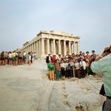 Zwei Reisegruppen, ein davon offenbar asiatisch, drängen sich vor die Akropolis in Athen, Griechenland