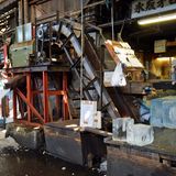 Antikes im Hightech-Land Japan: Eine uralte Maschine zerschreddert das Eis für die Kühlung in Eimer. Große Eisblöcke werden an Haken über den Fußboden gezogen oder auf dreirädrigen Elektrokarren transportiert.