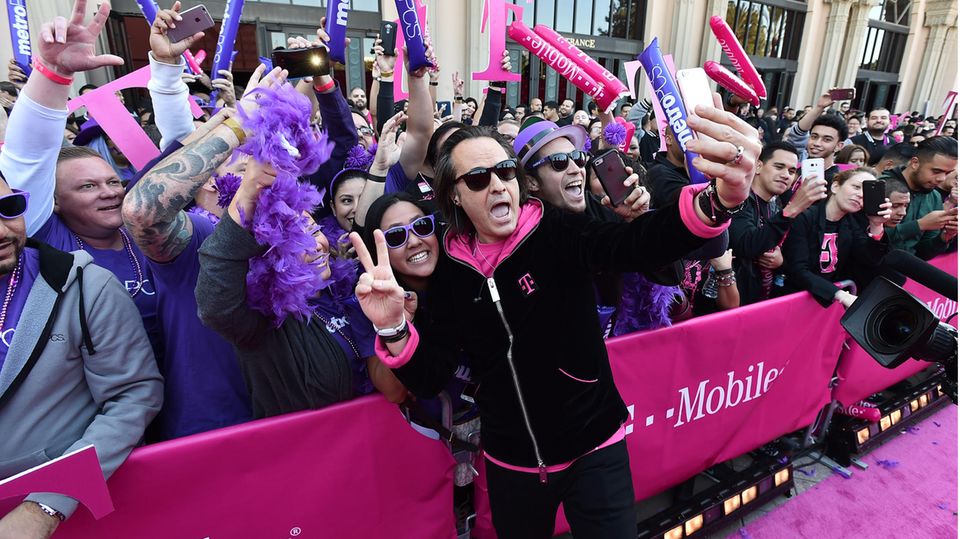 T-Mobile CEO John Legere takes a selfie with a crowd of fans