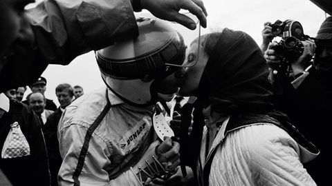 1968 GP Holland: Nach dem Sieg in Zandvoort küssen sich die Stewarts. Ein Helfer muss das Visier öffnen, denn die rechte Hand des Piloten ist stark bandagiert.  The Golden Age of Formula 1, Kleine Ausgabe - Rainer W. Schlegelmilch - 24,90 Euro