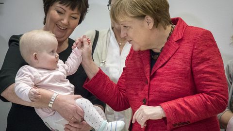 Angela Merkel auf einem Pressetermin mit einem Baby