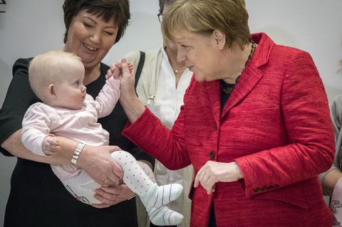 Angela Merkel auf einem Pressetermin mit einem Baby