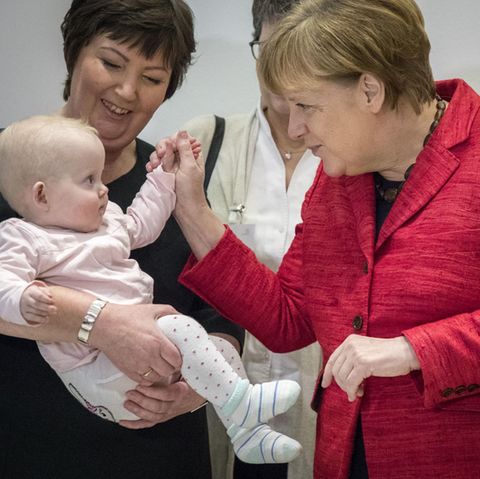 Angela Merkel auf einem Pressetermin mit einem Baby