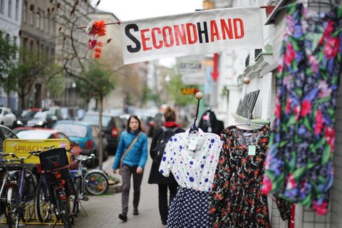 Eine Frau geht an einem Second-Hand-Shop vorbei.