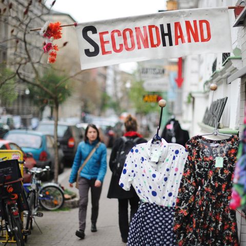 Eine Frau geht an einem Second-Hand-Shop vorbei.