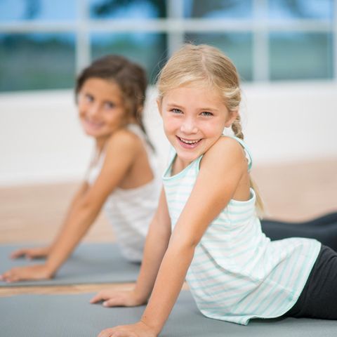 Zwei Mädchen in Turnzeug auf Yogamatten