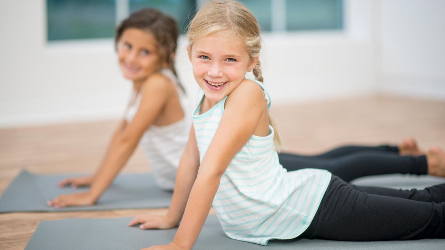 Zwei Mädchen in Turnzeug auf Yogamatten