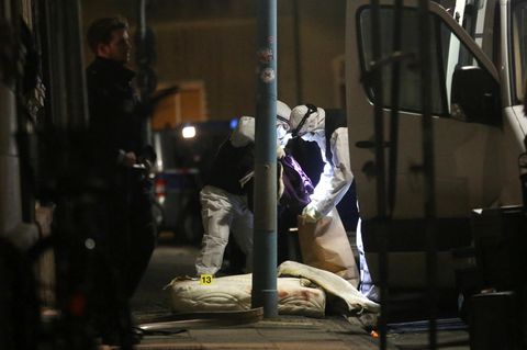 Polizisten der Spurensicherung untersuchen in Herne vor dem Haus, in dem es einen Wohnungsbrand gegeben hatte, eine Matratze.