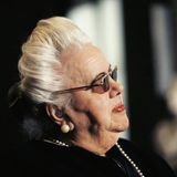 Eine alte Dame mit aufwendig frisiertem weißen Haar, bühnenreif geschminkt