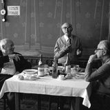 Drei alte Herren sitzen um einen gedeckten Tisch