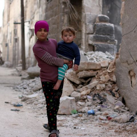 Ein Mädchen in Syrien trägt ihren kleinen Bruder auf dem Arm