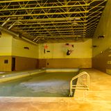 Das städtische Schwimmbad ist mit einer dicken Kruste aus Dreck und Staub bedeckt. Im Pool befindet sich noch Wasser.