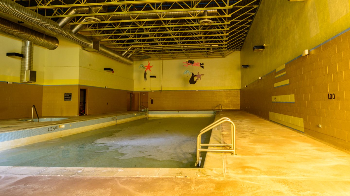 Das städtische Schwimmbad ist mit einer dicken Kruste aus Dreck und Staub bedeckt. Im Pool befindet sich noch Wasser.