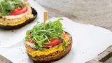 Weißer Burger  Zutaten:  250 g Hähnchenbrust, 1 Zwiebel, ½ TL Paprikapulver, ½ TL zerstoßener Szechuanpfeffer, 1 EL Bio-Tamari (glutenfreie Sojasauce), Meersalz, frisch gemahlener schwarzer Pfeffer, 2 EL Olivenöl, 4 Portobello-Pilze, 1 Handvoll Rucola, 1 Strauchtomate, 1–2 EL Tofunese (oder Mayonnaise aus dem Glas), 2 EL Schnittlauchröllchen, 1 EL Senf      Zubereitung:  1. Die Hähnchenbrust in dicke Streifen schneiden und durch die grobe Scheibe des Fleischwolfs drehen. Die Zwiebel abziehen und würfeln.  Zwiebel, Paprikapulver, Szechuanpfeffer und Tamari zum Fleisch geben.  Salz und Pfeffer zugeben. Alles kräftig verrühren, zwei flache Pattys daraus formen und mit etwas Olivenöl bestreichen.        2. Eine Grillpfanne aufheizen. Die Stiele der Portobello-Pilze abschneiden.  Die Pilze mit Salz und Pfeffer bestreuen und mit Olivenöl bestreichen. Pilze und Pattys in der Pfanne von beiden Seiten 2–3 Minuten kräftig anbraten.  Die Temperatur auf ein Drittel herunterschalten und beides weitere 5 Minuten braten lassen.        3. Den Rucola waschen und trocken schleudern. Die Tomate waschen, Blütenansatz entfernen und die Tomate in dünne Scheiben schneiden.  Die Tofunese mit dem Schnittlauch verrühren.        4. Zwei Portobello-Pilze mit der runden Seite nach unten auf einen Teller setzen. Mit dem Senf bestreichen. Die Hähnchenburger darauf legen, 1 TL Tofunese daraufgeben und mit Tomatenscheiben und Rucola bedecken.  Zuletzt nochmals einige Tupfen Tofunese darauf verteilen und mit den anderen beiden Pilzen bedecken. Mit einem Holzspieß feststecken.