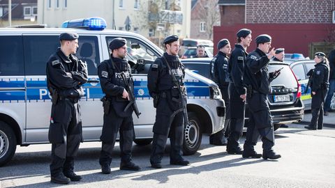 Die Polizei sperrt in Duisburg eine Straße, in der eine Bank überfallen wurde