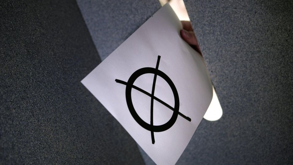 Ein Wahlzettel wird in eine Urne gesteckt (Symbolbild)