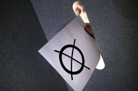 Ein Wahlzettel wird in eine Urne gesteckt (Symbolbild)
