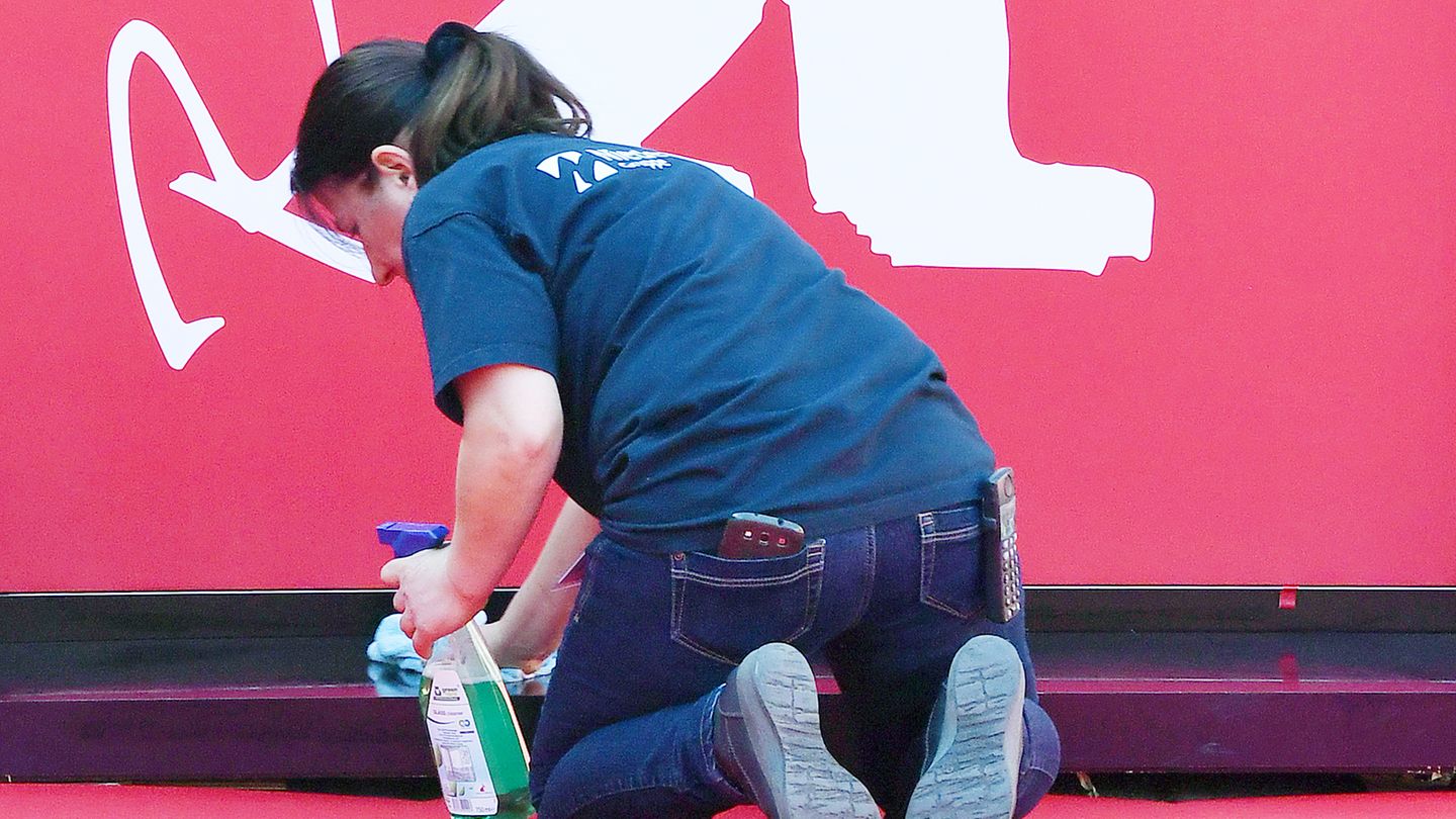 Eine Frau kniet bei der Berlinale auf dem Boden und reinigt einen Vorsprung