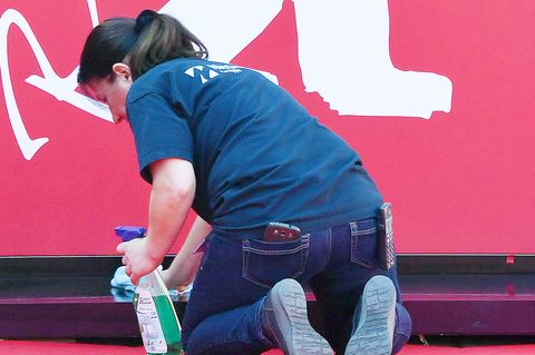 Eine Frau kniet bei der Berlinale auf dem Boden und reinigt einen Vorsprung