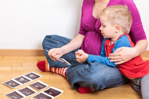 Ein kleiner Junge und seine Mutter betrachten Ultraschallfotos