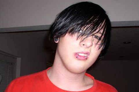 Emo-Kid mit langen, schwarzen Haaren und Piercings