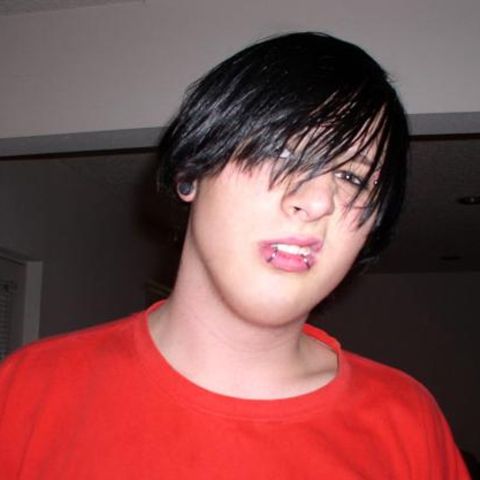 Emo-Kid mit langen, schwarzen Haaren und Piercings