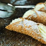 Cannoli  Cannolo ist ein gefülltes Gebäck, das aus Sizilien stammt. Meist besteht es aus einer frittierten Teigrolle mit einer süßen cremigen Füllung aus Ricotta. Die ist entweder mit Vanille, Kakao, Schokostückchen oder kandierten Früchten verfeinert. 