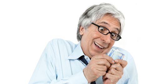 Ein Manns schaut freudig auf einen Geldschein
