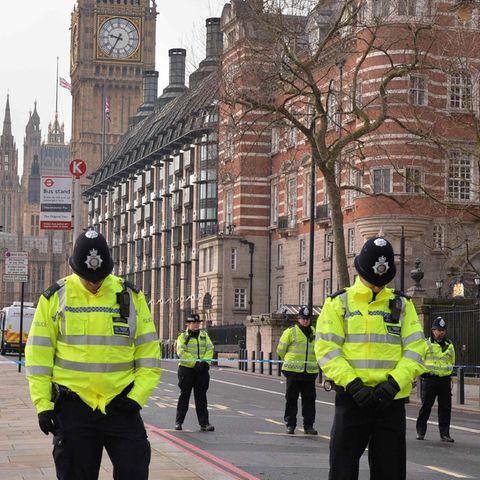 Während der Schweigeminute für die Opfer des Anschlags von London stehen Polizisten mit gesenkten Köpfen still