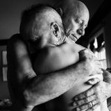 Die Eltern umarmen sich mit blankem Oberkörper