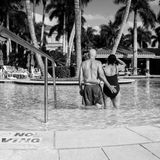 Die Eltern stehen im Swimmingpool mit dem Rücken zur Kamera
