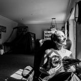 Laurel sitz am Fenster mit zwei Silvesterhütchen auf der Brust