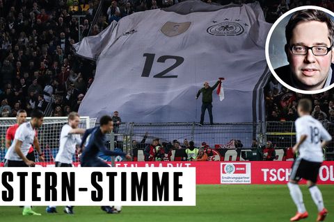 Fußballer der Nationalelf vor einer Tribüne mit Zuschauern