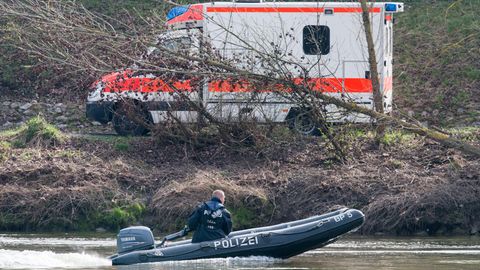Ein Schlauchboot der Polizei auf der Donau, am Ufer steht ein Rettungswagen