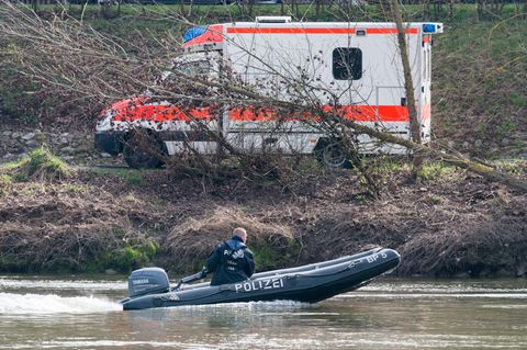 Ein Schlauchboot der Polizei auf der Donau, am Ufer steht ein Rettungswagen