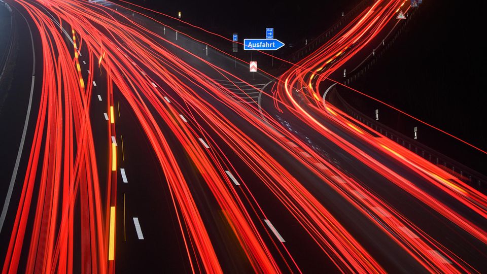 Durch Langzeitbelichtung werden die Schweinwerfer auf einer Autobahn zu Leuchtspuren
