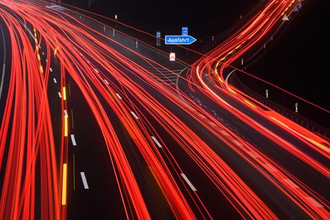 Durch Langzeitbelichtung werden die Schweinwerfer auf einer Autobahn zu Leuchtspuren