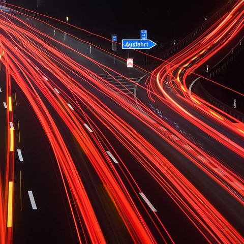 Durch Langzeitbelichtung werden die Schweinwerfer auf einer Autobahn zu Leuchtspuren