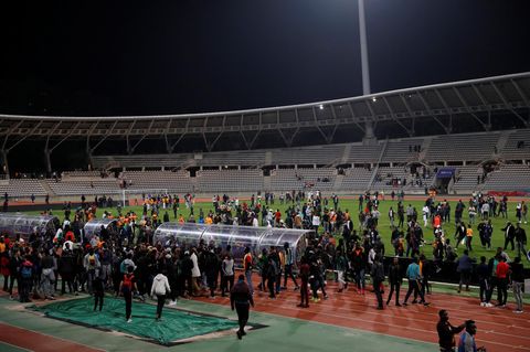 Zu sehen ist die Rasenfläche des Stadions, auf der Dutzende Menschen stehen.