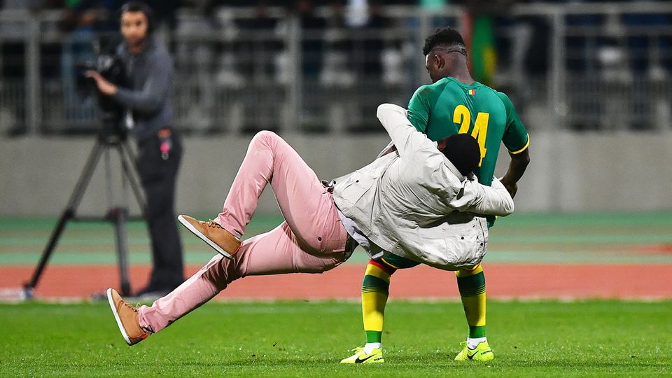 Ein Zuschauer springt Senegals Lamine Gassama an. Ein Zuschauer springt Senegals Lamine Gassama an.