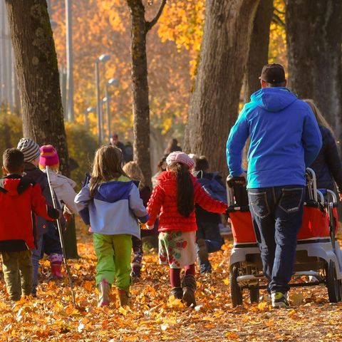 Kinder gehen mit Erwachsenen spazieren (Symbolbild)