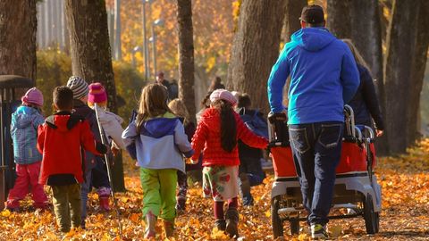 Kinder gehen mit Erwachsenen spazieren (Symbolbild)