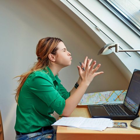 Eine Frau sitzt frustriert vor ihrem alten, dicken Notebook